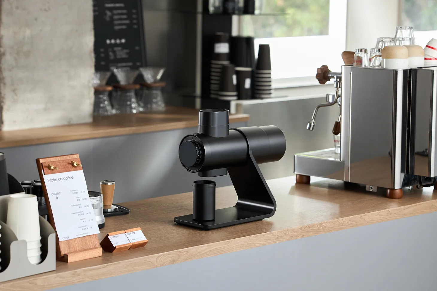 Barsetto E6Air black grinder on a cafe counter with magnetic portafilter cup